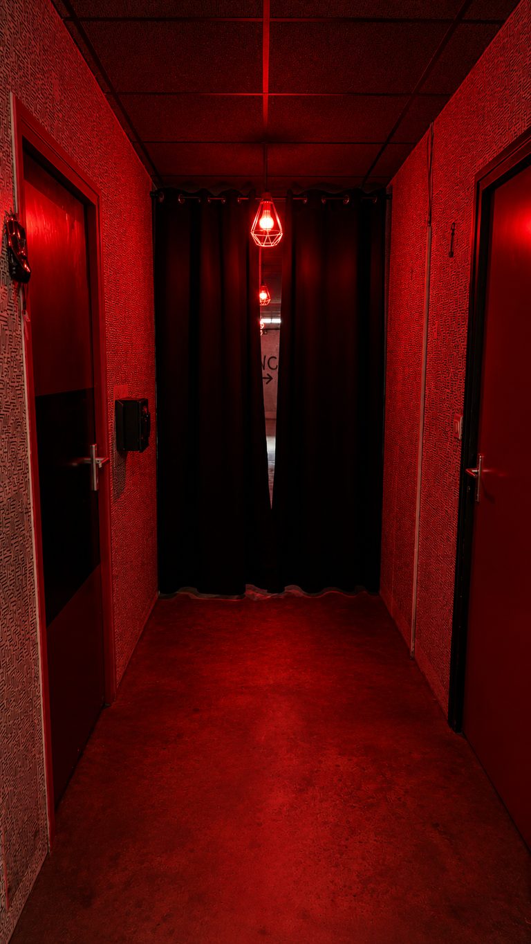 Couloir oppressant éclairé en rouge sang de la salle Psychiatric — escape game horreur à Caen Mondeville GAMEDOOR·41