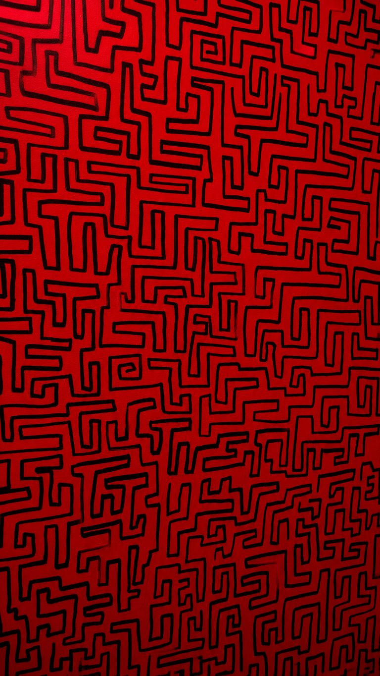 Mur graphique à motif labyrinthe rouge - signature visuelle GAMEDOOR·41 escape game à Caen Mondeville