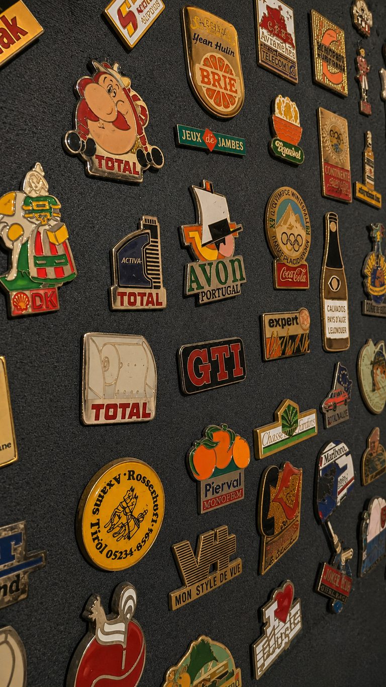 Mur de pin's vintage années 80 dans la salle Back to the 80's de l'escape game GAMEDOOR·41 à Caen Mondeville